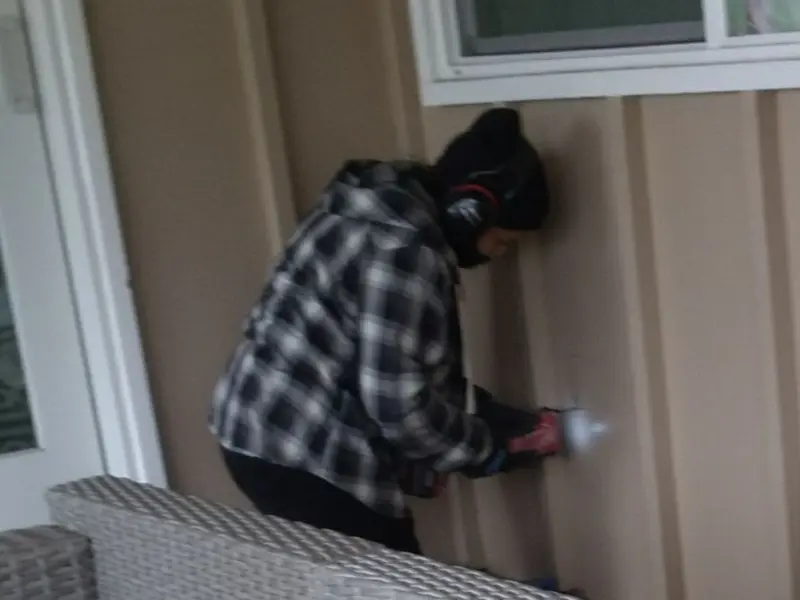 Professional electrician installing an exterior outlet in Riga
